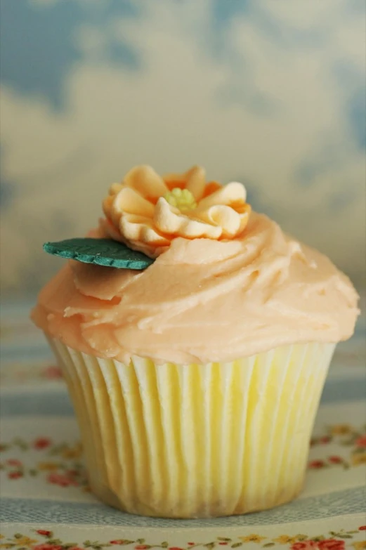 the cupcake is decorated with flowers and has frosting