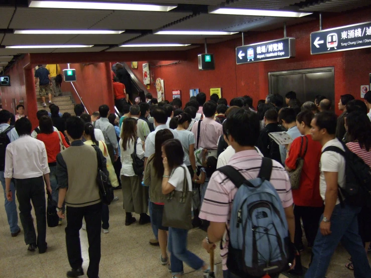 a group of people are standing in a train station