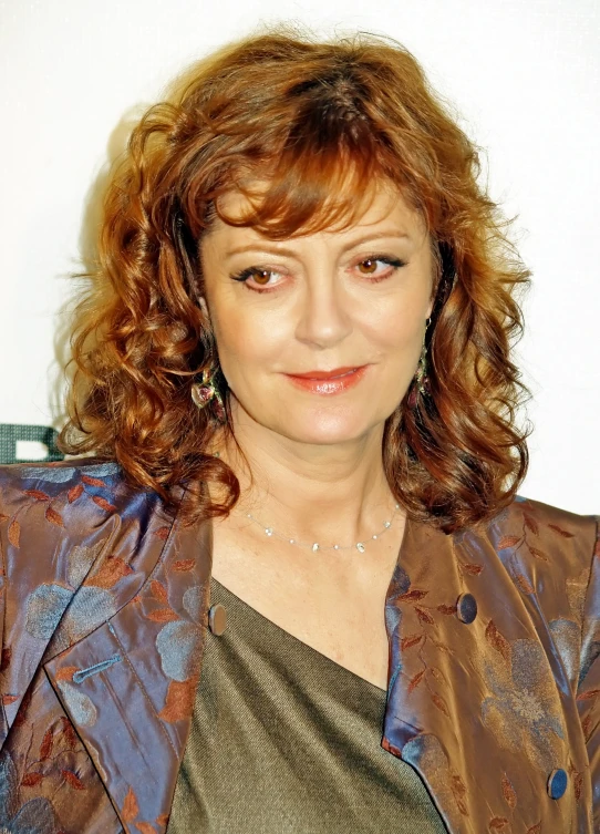 a woman with red hair wearing a brown jacket