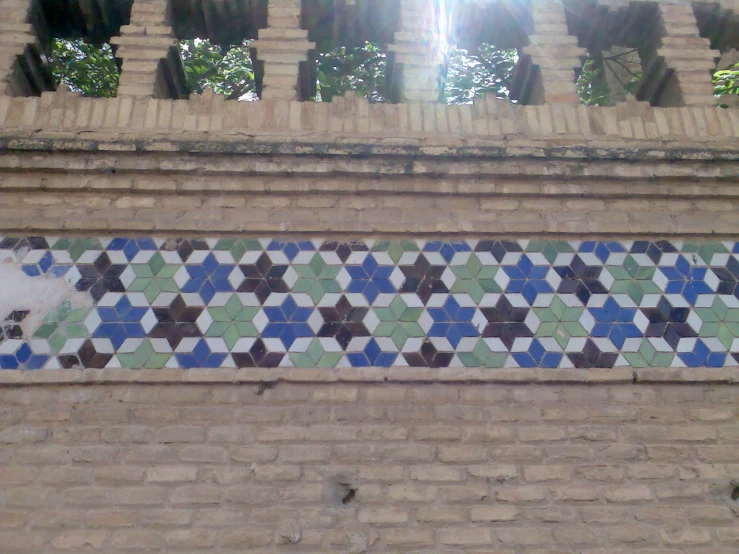 a wall with different designs on it next to a brick building