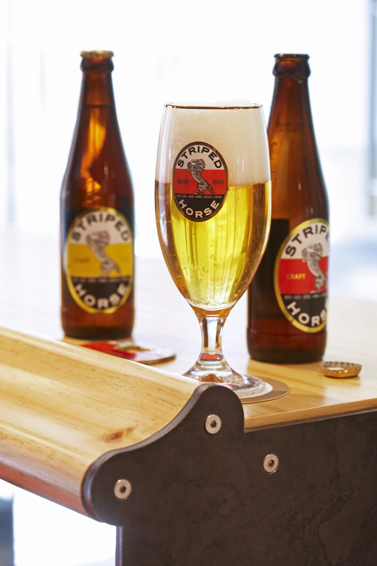 a glass of beer sits next to three bottles