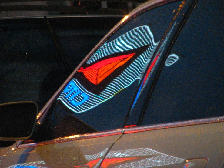 a car's side window is seen with colorful patterns on it