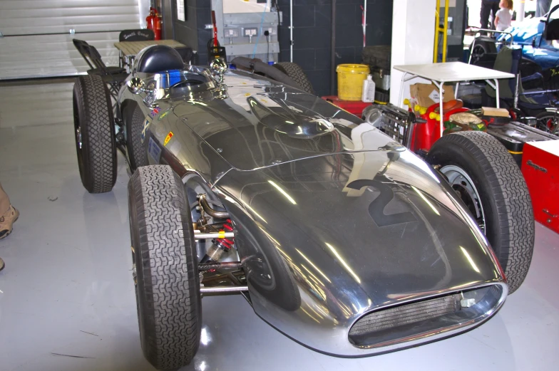 an antique race car sitting in the garage