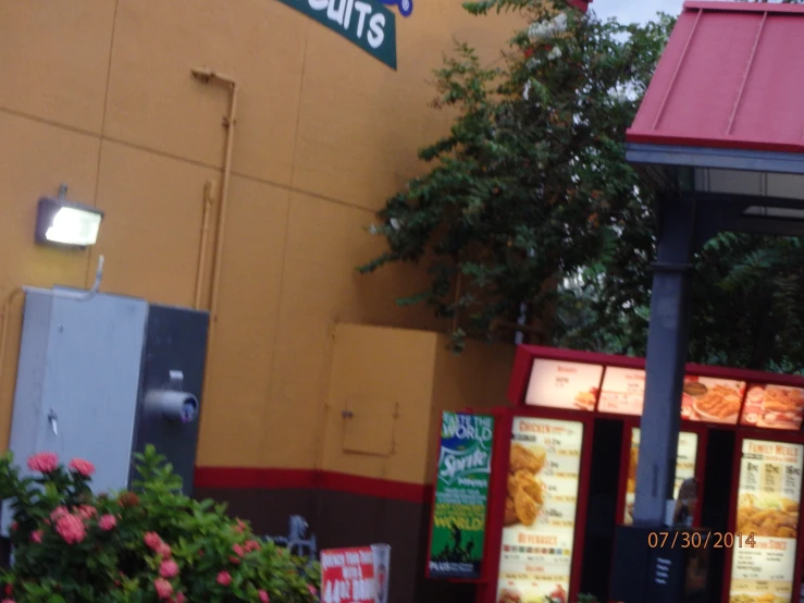 a restaurant with plants surrounding it and a sign for a donut shop on the front