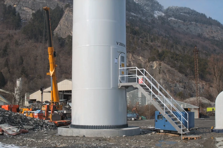 there is a large metal pipe and a ladder near some construction equipment