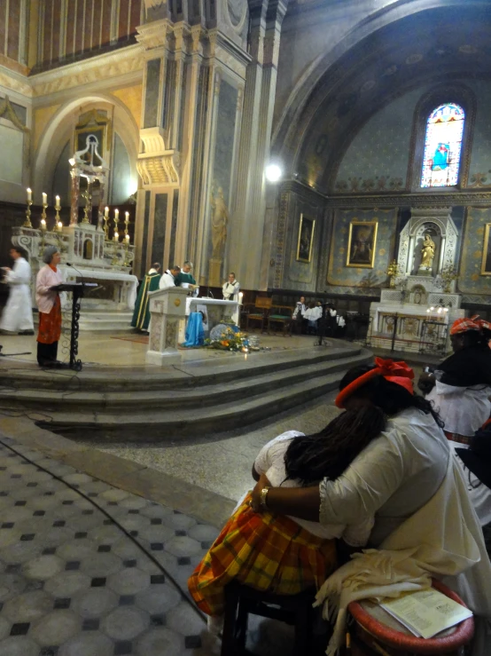 a priest standing on stage at an alter of a church