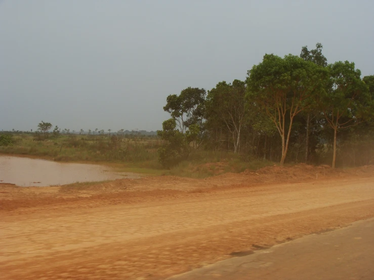 a truck on a dirt road near a small body of water