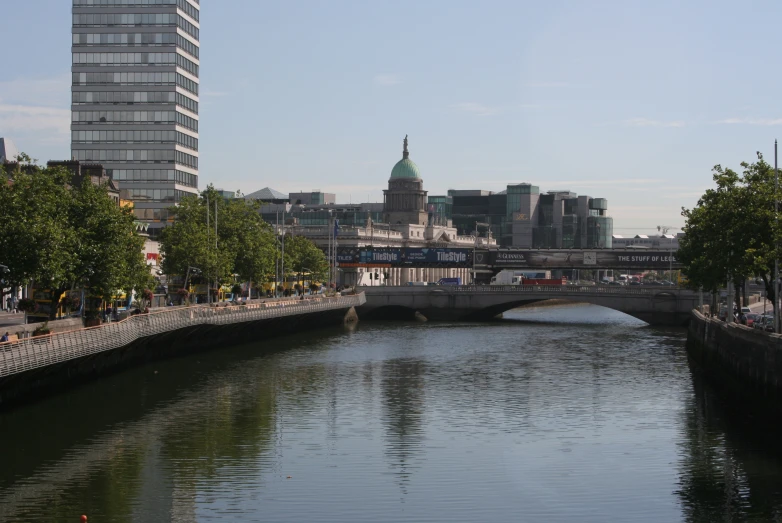 a river in a city with buildings and a bridge over it