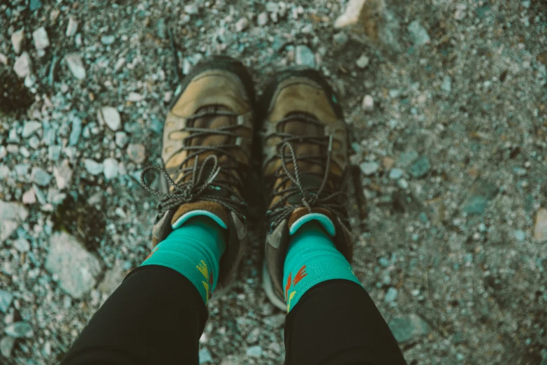 the green socks and brown shoes are seen from down below