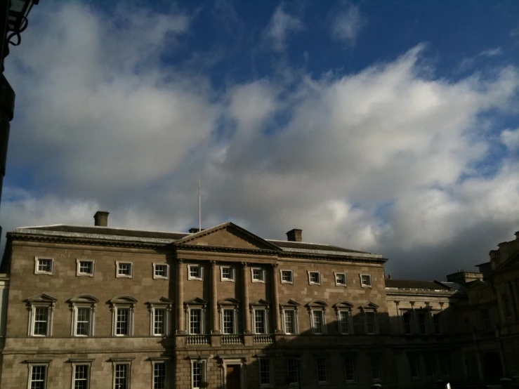 two large brown brick buildings under a cloudy sky