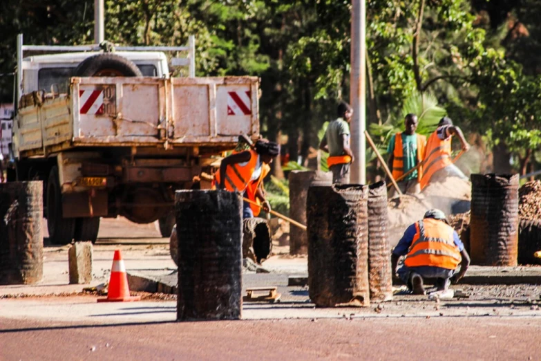 a couple of men in construction gear by a tractor