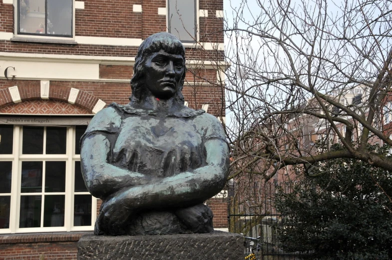 a statue of a person sitting in front of some trees