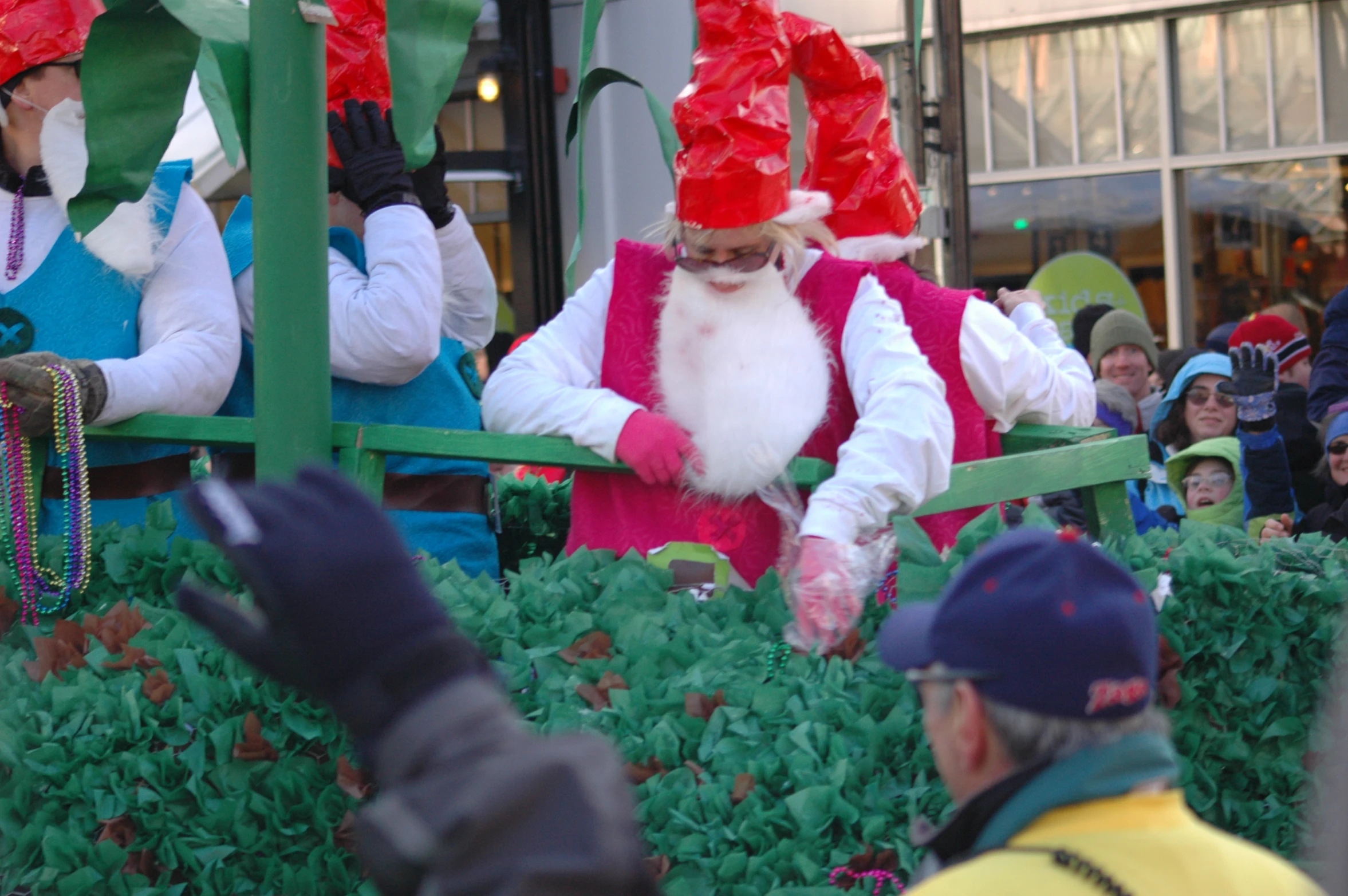 a parade with santa claus walking in between the people