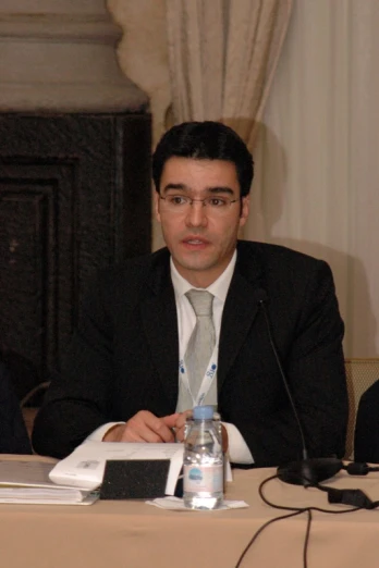 a man sitting at a table in a business suit
