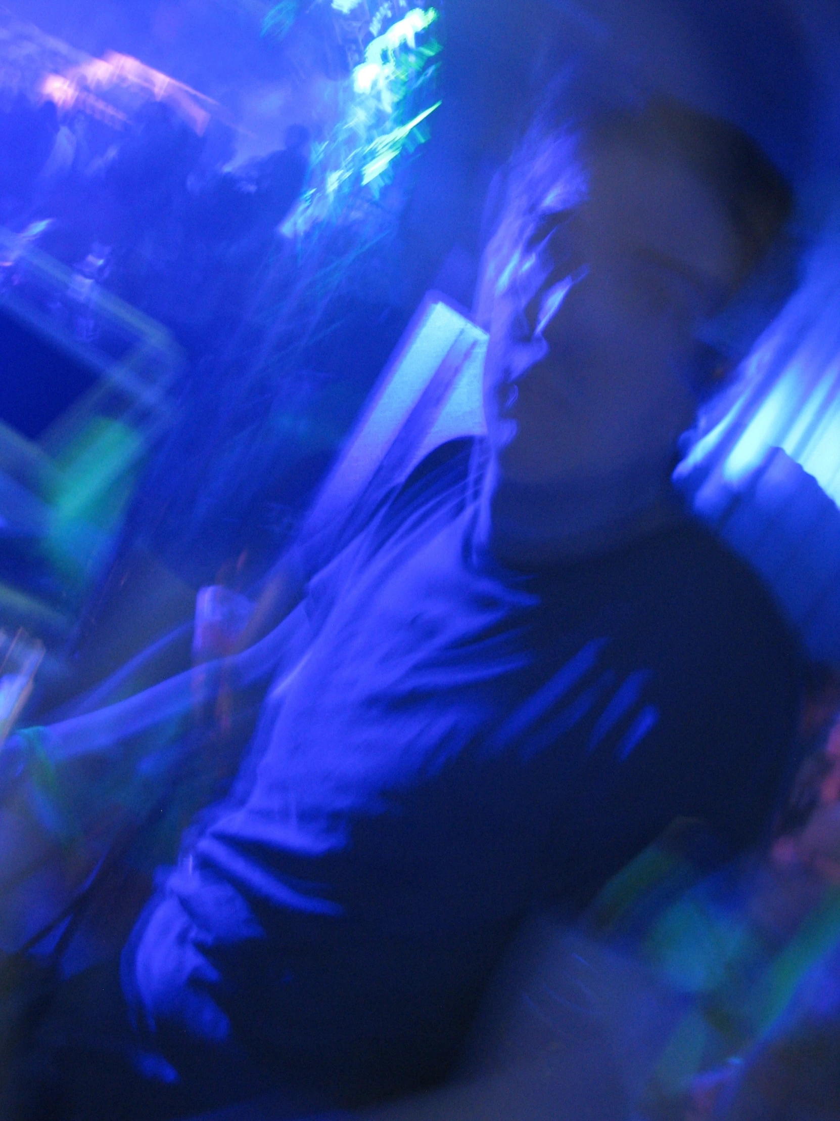 a man standing in a room with green and blue lights