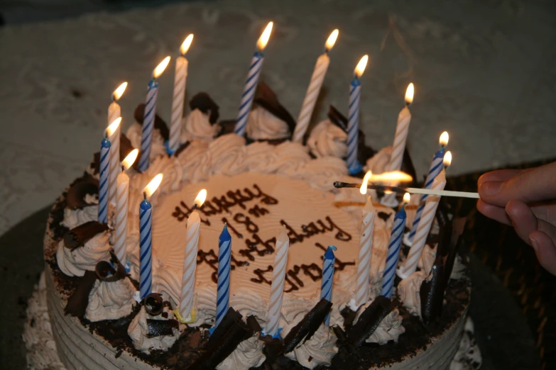 someone is lighting candles on a birthday cake