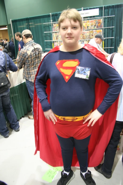 a man dressed in a superman suit stands before a crowd