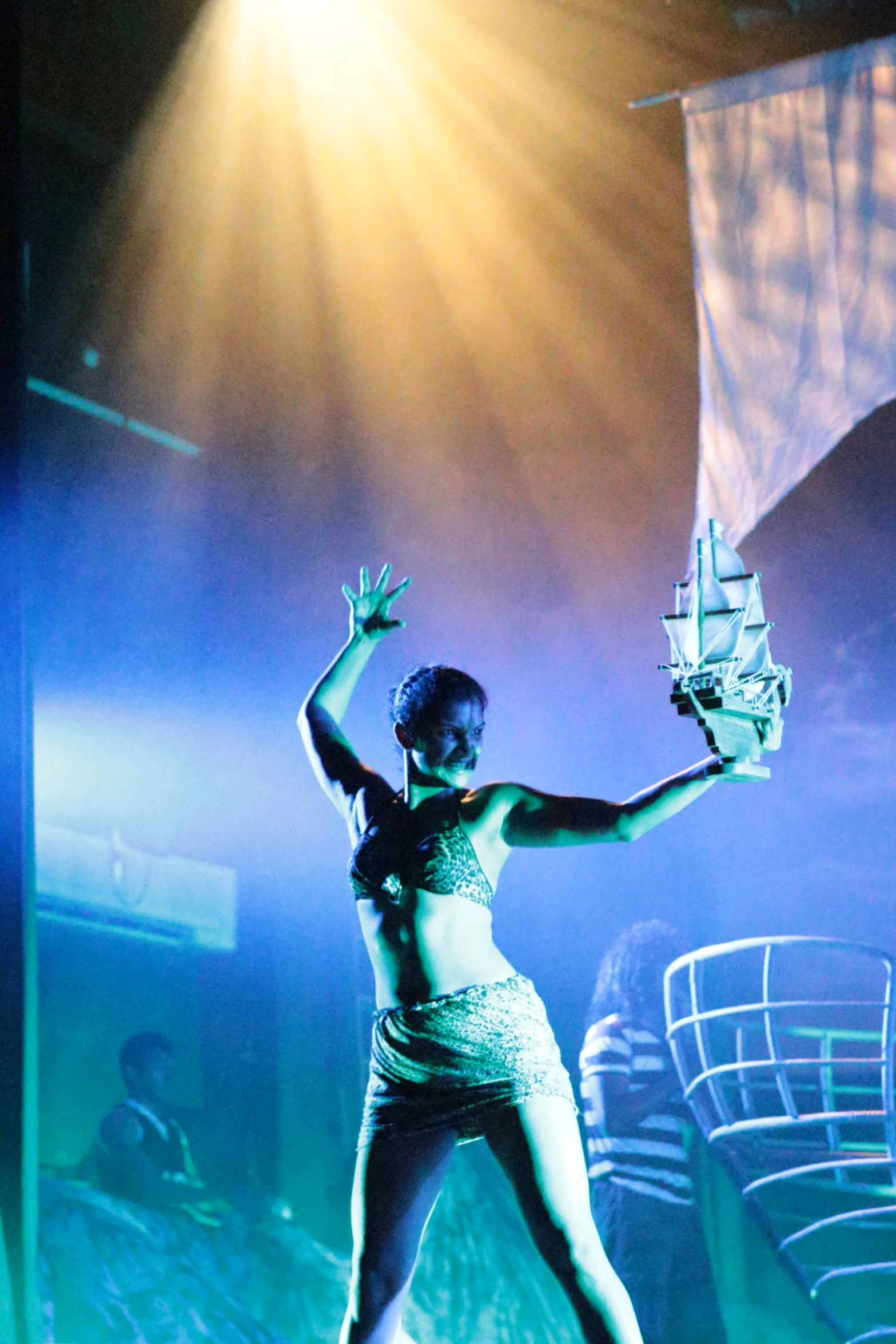 woman in silver dress standing on stage in front of audience