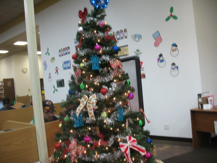 there is a small decorated christmas tree in the office