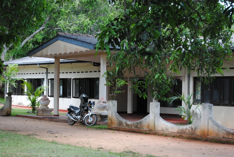 a motorcycle sits outside of a small building