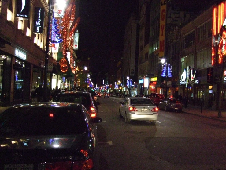 a view of a car, parked on a city street at night