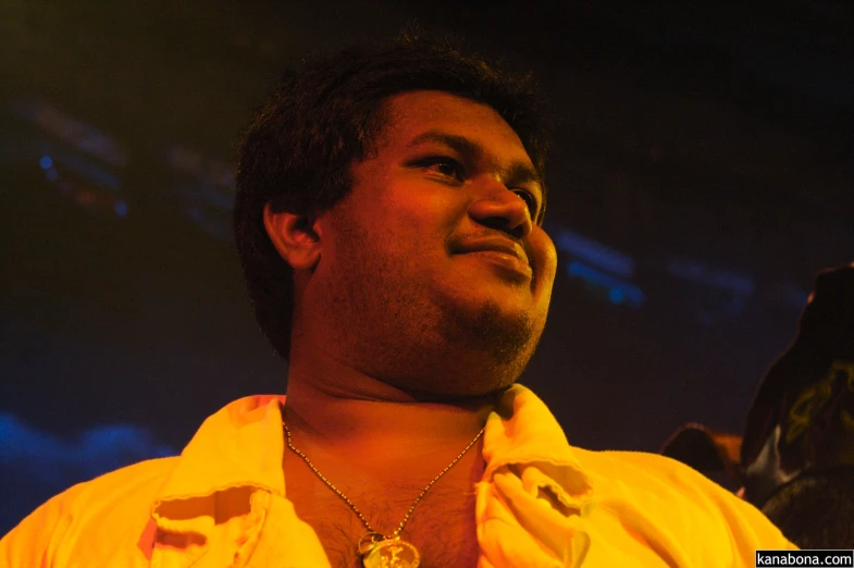 a young man is looking to the sky while wearing a necklace