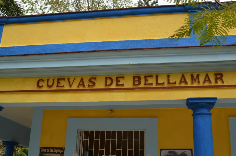 a yellow and blue building with a sign that reads cuejas de bellamar