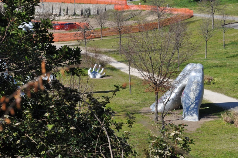 the sculpture sits at the edge of a garden