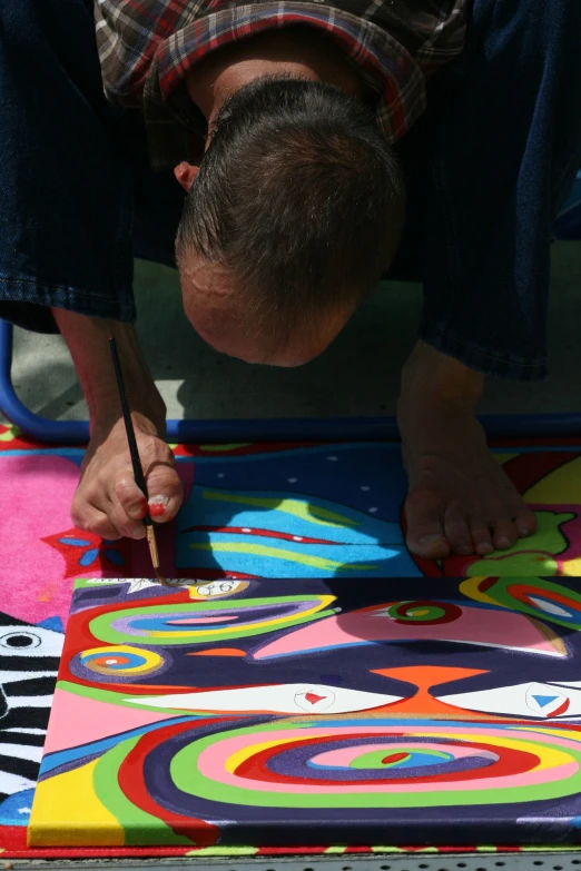 an artist is painting with paint on the ground