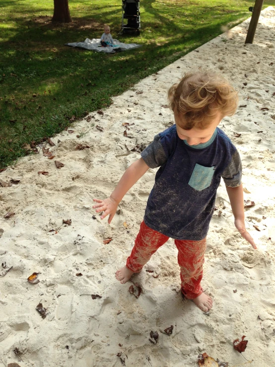 a young child plays in the sand at the park