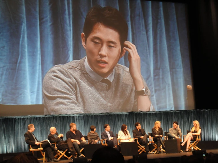 actors and crew on stage for a panel presentation