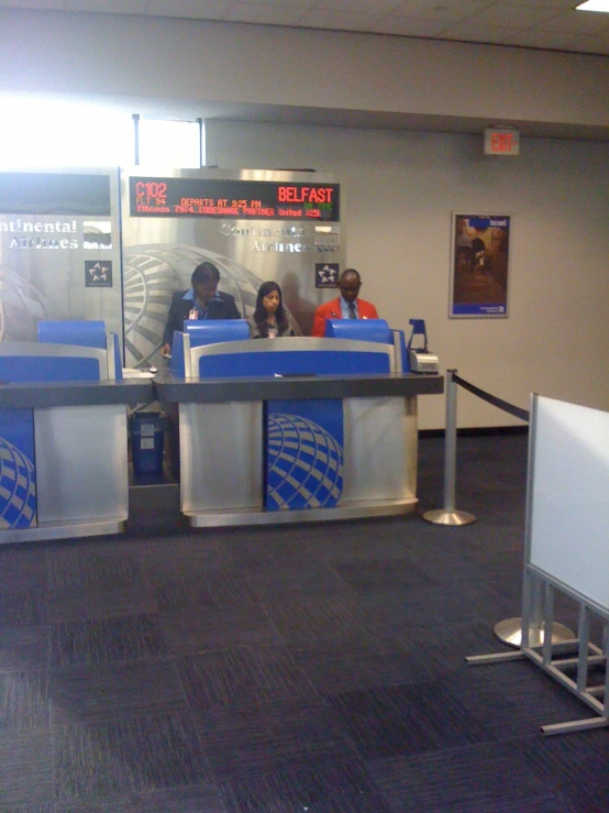 people are at a metal fence and check in desks