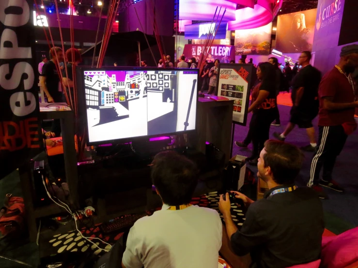 a person with a video game controller sits in front of a crowd