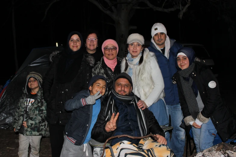 a group of people taking a po at night with their dog