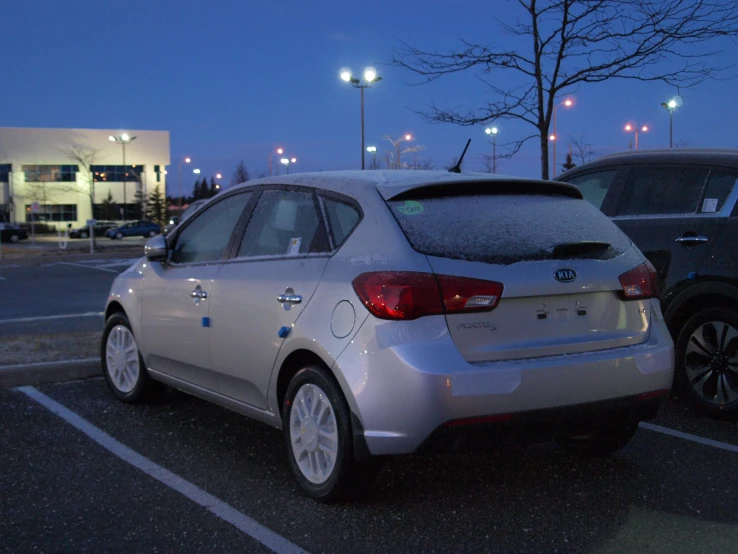 a silver car that has a rear tire sticker on it