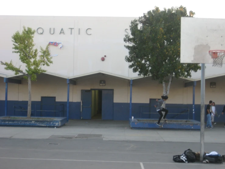 people stand near a basketball court with two large boards on the sides of them