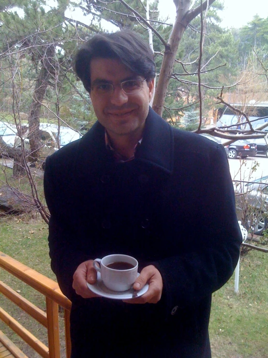 a man is holding a cup of coffee