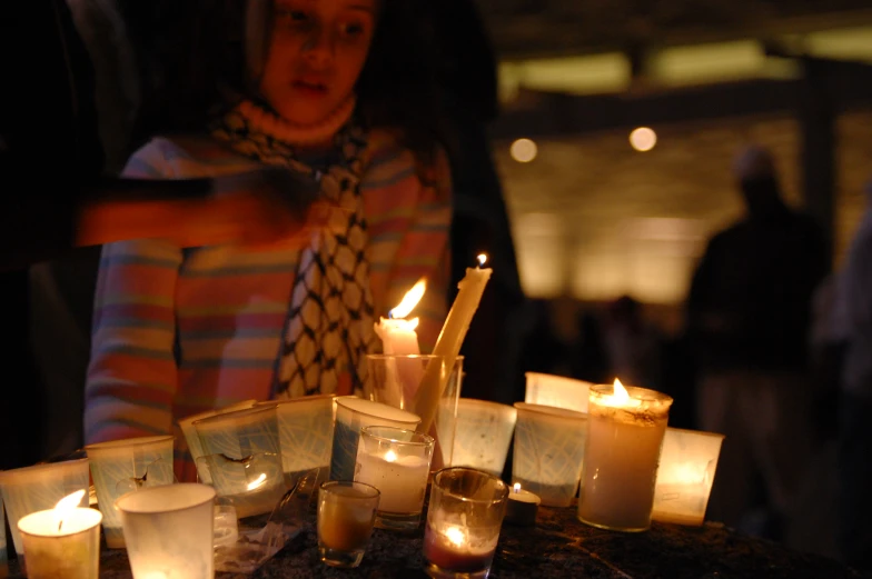 many candles, lit up and sitting on top of a table