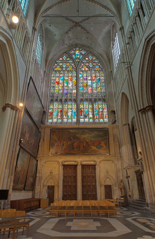 an old building with stained glass windows and a large painting on the wall