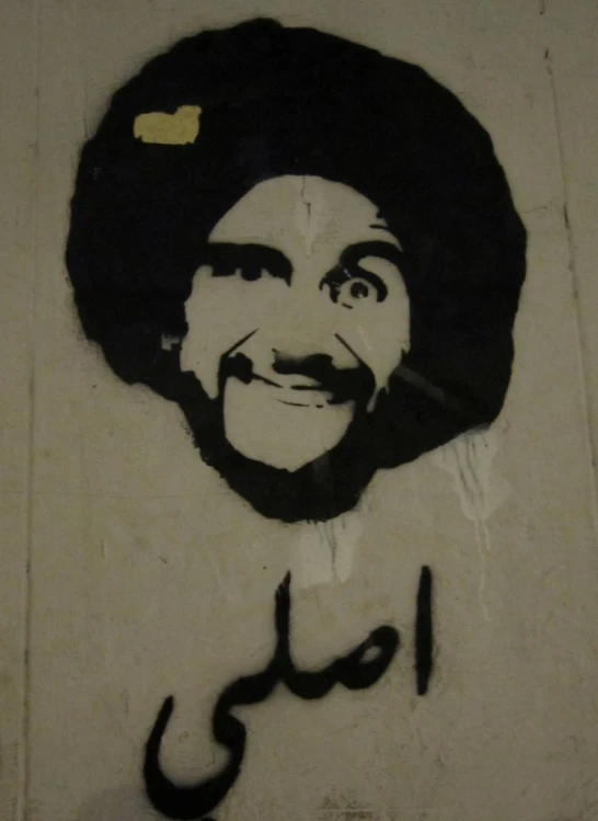 a street scene with the face of a man written in arabic