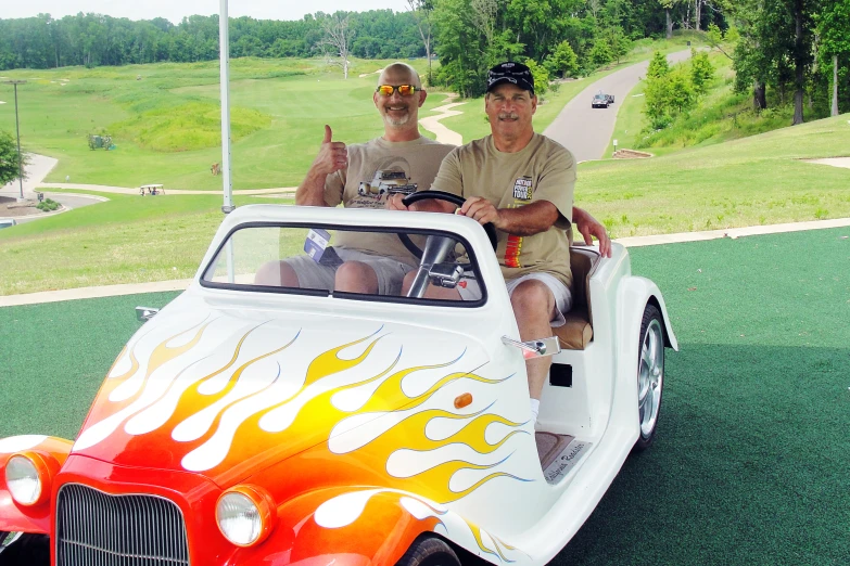 two men in  rods ride in an old fashioned car