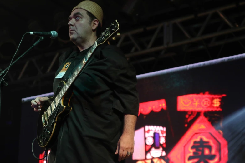 a man holding a guitar in front of his face