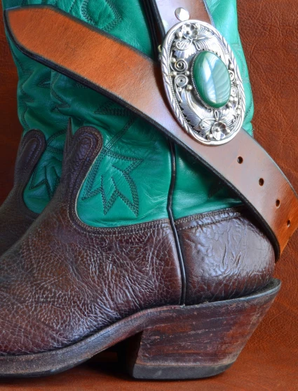 a close up of a cowboy's boot with green and brown leather