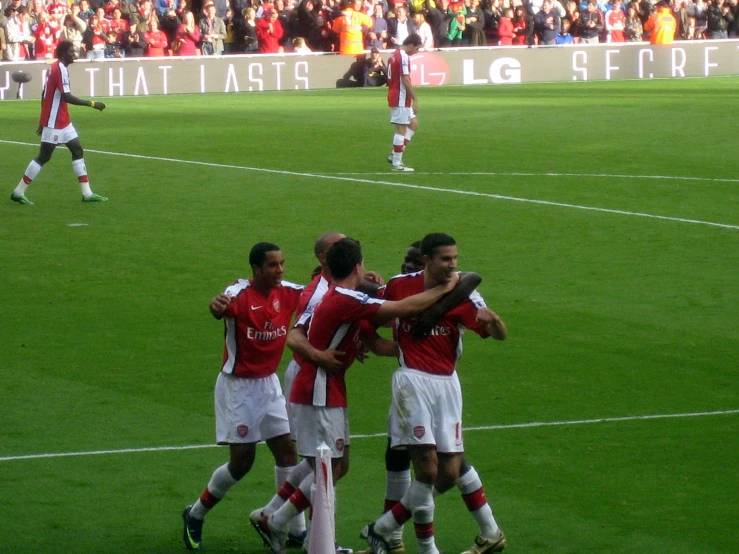 four soccer players celeting on a field