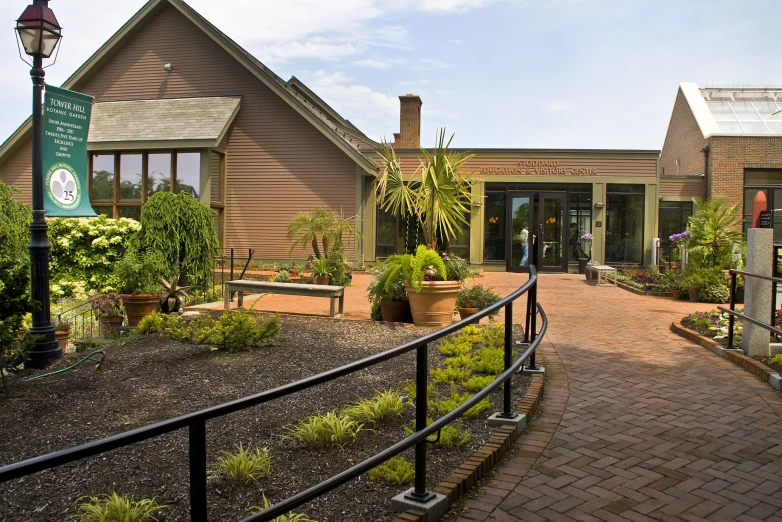 a garden house with a brick walkway leading up to the door