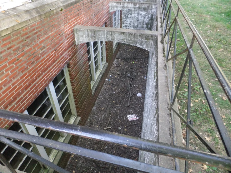 a large building with metal railing next to a grass field