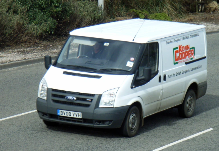 a delivery truck on a road near some brush