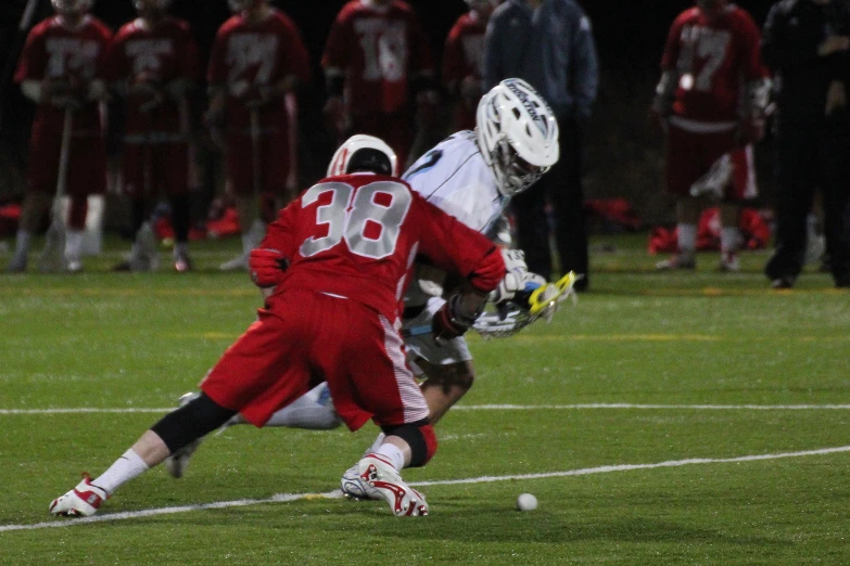 the lacrosse player is jumping into the air after hitting the ball