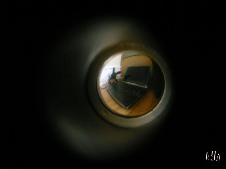 a reflection of a desk with a laptop and mouse