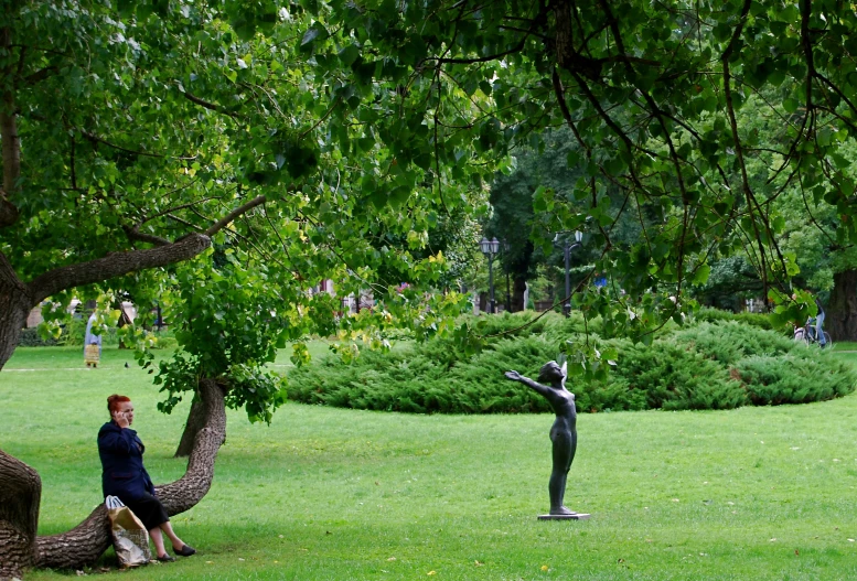 a man and woman sitting on a bench in a park